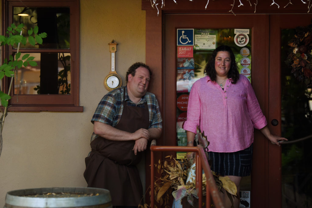 Chefs and co-owners Daniel Kedan and Marianna Gardenhire next to their entrance door covered with local accolades and Michelin Guide recommendations at Backyard restaurant which is permanently closing June 6 after making it through the pandemic in Forestville, Calif. on Tuesday, May 18, 2021. The couple will be cooking every other weekend at Davis Family Vineyards and they plan to offer their signature fried chicken at this year’s Gravenstein Apple Fair.(Photo: Erik Castro/for The Press Democrat)
