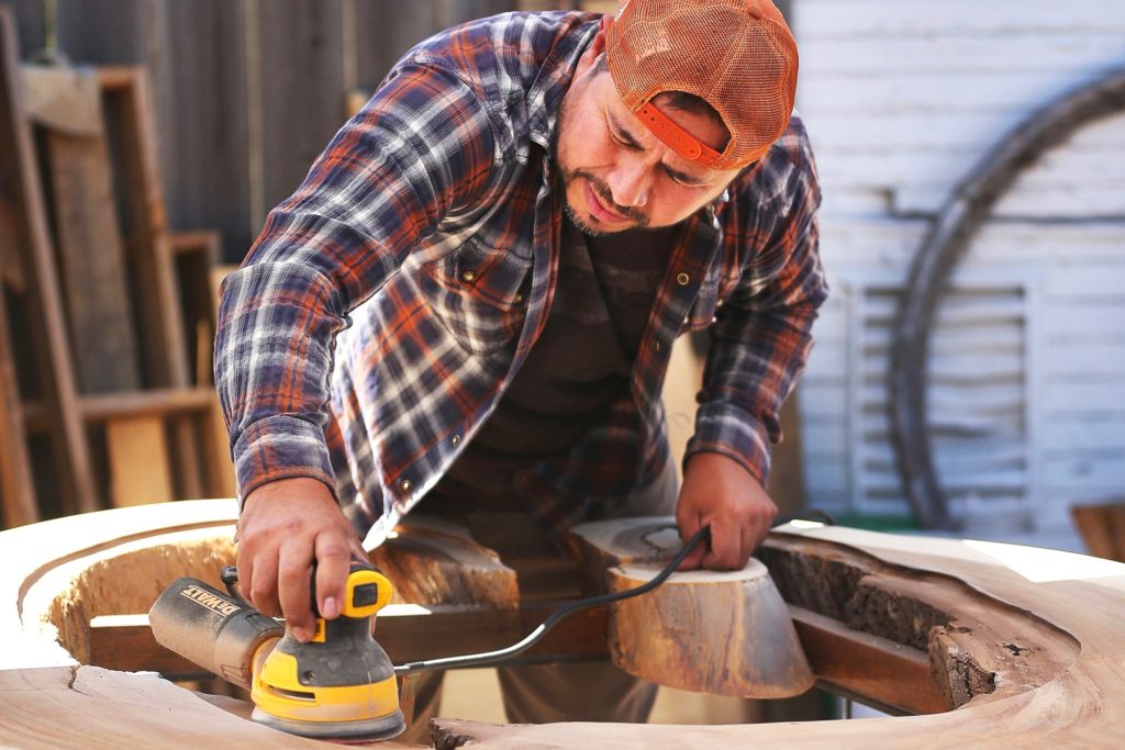 Jorge Martinez works on creating a table out of a Parota tree at his Wine Country Decor store in Santa Rosa. (Christopher Chung/The Press Democrat)