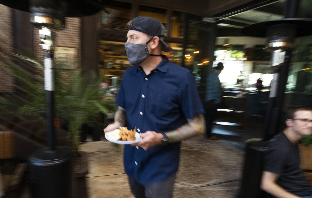 Matthew Williams, chef-owner of Khom Loi restaurant in Sebastopol, takes a dish to a table on Thursday, August 5, 2021. (Photo by John Burgess/The Press Democrat)
