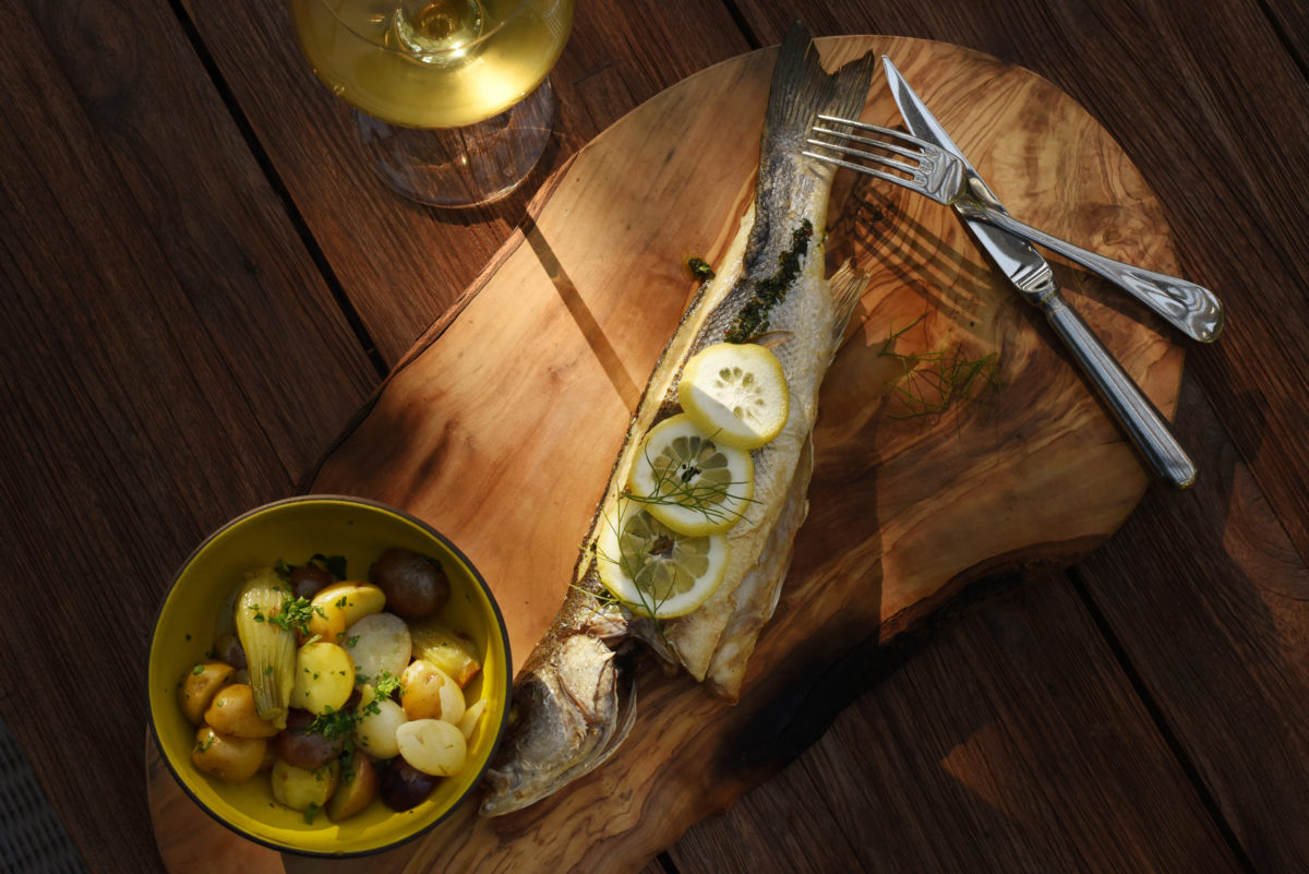 Whole roasted sea bass with fingerling potatoes, fennel, pearl onion, lemon and garlic seed with a glass of Walt Sonoma Coast Chardonnay at Layla restaurant at MacArthur Place Hotel and Spa in Sonoma. (Erik Castro/for The Press Democrat)