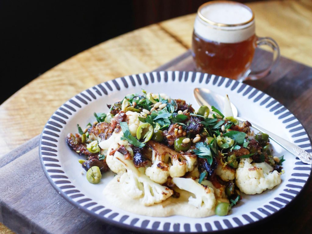 Roasted cauliflower on a bed of pureed chickpeas, and topped with roasted figs, chopped green olives, pine nuts, parsley, and lemon by chef Crista Luedtke. (Beth Schlanker/The Press Democrat)