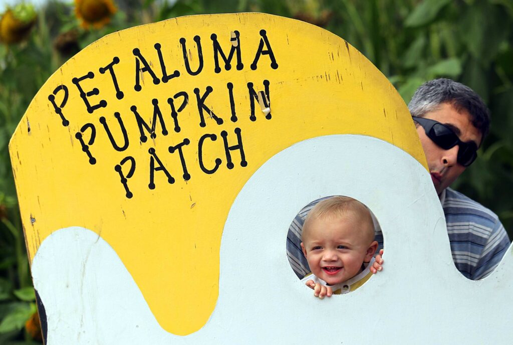 Christian Viebrock holds up his son Theo at the Petaluma Pumpkin Patch and Amazing Corn Maze in Petaluma. (John Burgess/The Press Democrat)