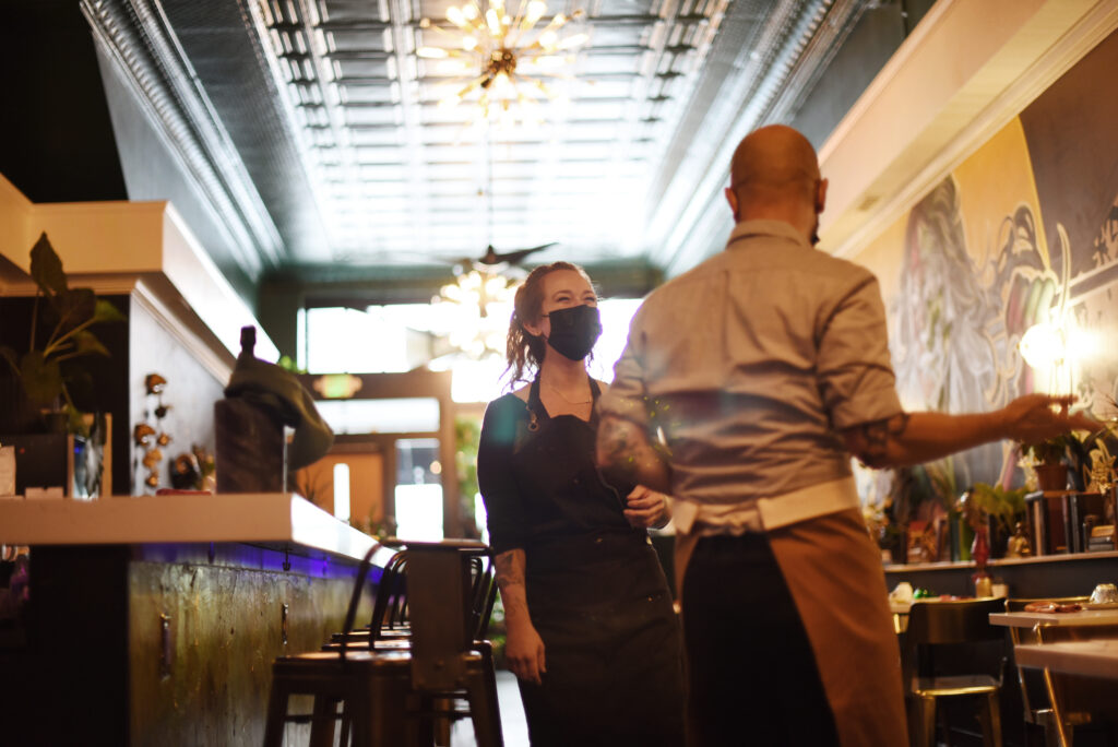 Owner Melissa Matteson, left, says she greatly appreciates the professional skills of her only waiter Leonardo Santoni, right, as the two work tirelessly to meet the needs of their dining guests at 4th Street Social Club restaurant in downtown Santa Rosa, Calif., on Saturday, Sept. 18, 2021. (Erik Castro / For The Press Democrat)