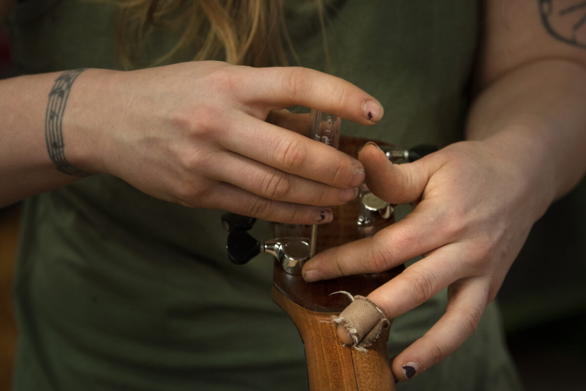 Guitar maker Maegen Wells, 32, putting on tuning pegs to the head of one of her small body archtop acoustic guitars in her home-based workshop in Forestville. (Erik Castro/for Sonoma Magazine)