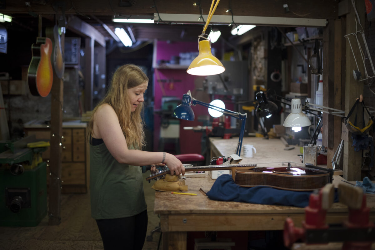 Guitar maker Maegen Wells, 32, in her home-based workshop while assembling one of her small body archtop acoustic guitars in Forestville. (Erik Castro/for Sonoma Magazine)