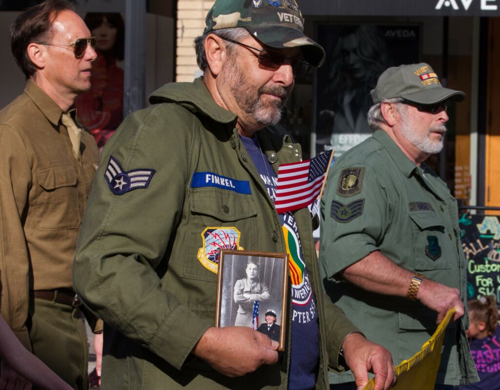 A Vietnam War veteran marches holding a picture at the 2017 annual Veteran's Day Parade in Petaluma, on Saturday, November 11, 2017. (Photo by Darryl Bush / For The Press Democrat)