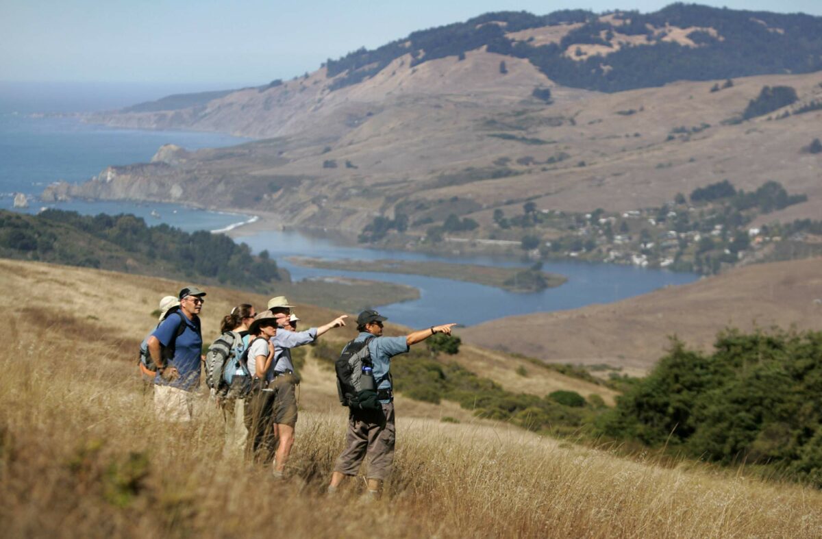 LandPaths executive director Craig Anderson, right, leads a walk to Red Hill from Shell Beach above the mouth of the Russian River. (John Burgess/The Press Democrat)
