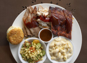 Three-way Smoker Combo with ribs, chicken, brisket and sides of Mac N' Cheese and Okra/Corn/Cherry Tomato Saute from Sweet T's Restaurant + Bar in Windsor. (John Burgess/The Press Democrat)