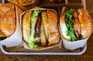 Sonoma Beef Burger with onion rings, fried chicken burger, chili fries and Cajun fries from Acme Burger. (Heather Irwin/Sonoma Magazine)