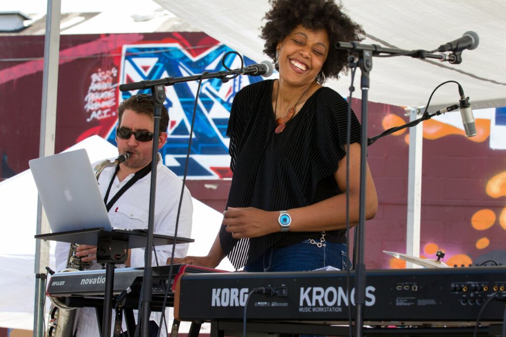 Eki Shola, front, sings and plays keyboards with Michael Fortunato, back left, playing saxophone, at the Out There Exposition in Santa Rosa on Sunday, April 29, 2018. (DARRYL BUSH/ FOR THE PRESS DEMOCRAT)