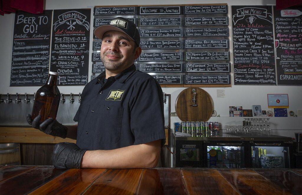 Peter Lopez Jr., owner of Juncture Taproom & Lounge, is now selling 32-oz growlers out of his Santa Rosa restaurant. Lopez is only taking phone-in to-go orders for food and offers over 20 varieties of beer and cider to fill your growler. (John Burgess/The Press Democrat)