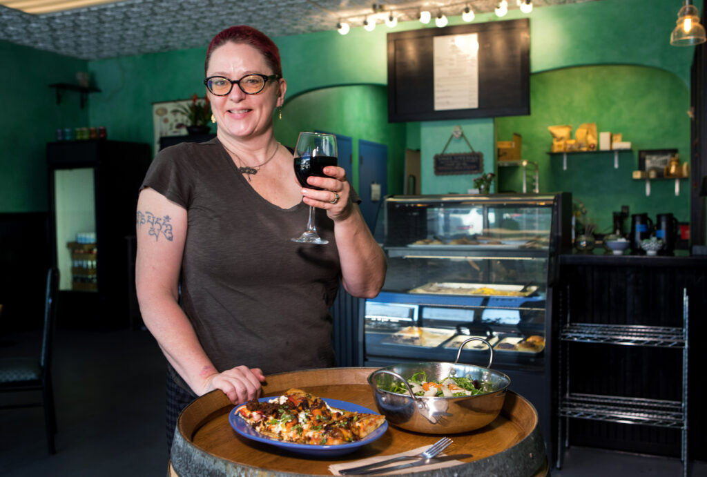 Owner, Greta Canton, displays some of her favorite dishes, slices of vegan pizza, a signature salad and wine, at Magdelena's Savories & Sweets, in Petaluma, Calif., on Saturday, February 19, 2022. (Photo by Darryl Bush / For The Press Democrat)