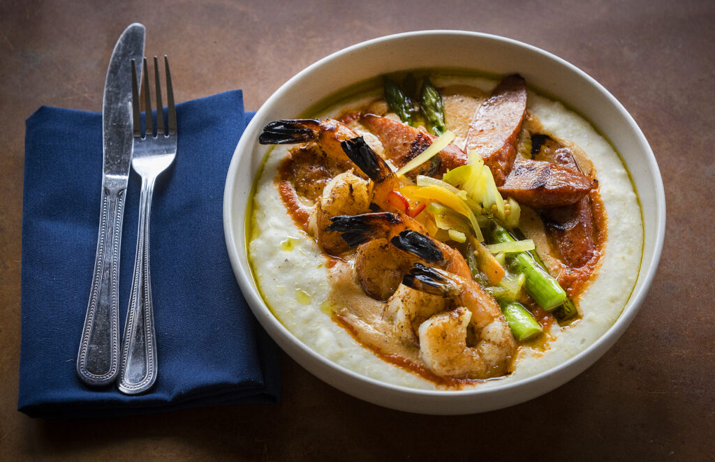 Shrimp and Grits with andouille sausage, sauce creole, trinity pickles and asparagus from Easy Rider in Petaluma on Tuesday, March 1, 2022. (John Burgess/The Press Democrat)