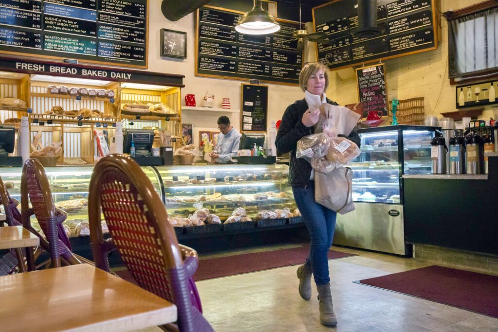 Tracy Yosten picks up some bread from the Basque Boulangerie on First Street East on Wednesday, Mar. 18. The bakery plans to remain open for the duration. (Photo by Robbi Pengelly/Index-Tribune)
