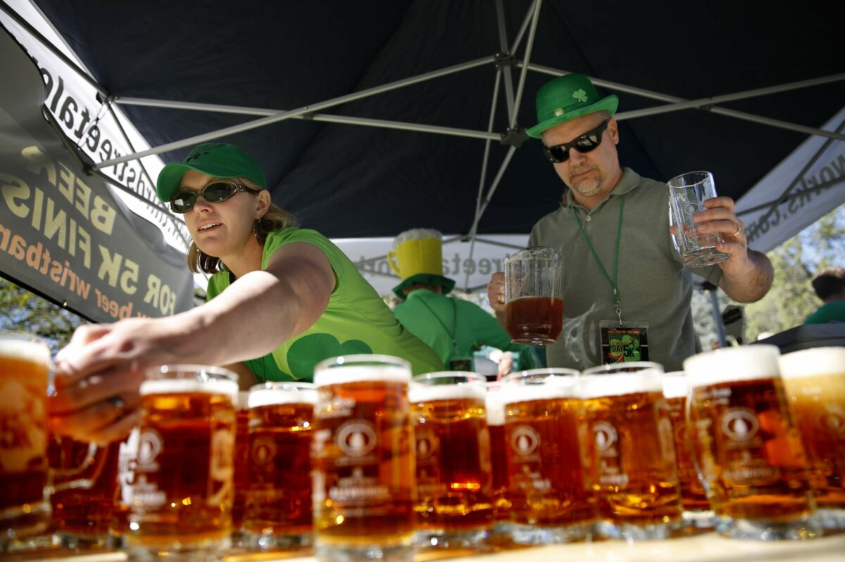 Santa Rosa City employees Jeanne Pugh and John Stinson pour mugs of beer at Juilliard Park during the St. Patrick's Day 5K in Santa Rosa. (Beth Schlanker/The Press Democrat)