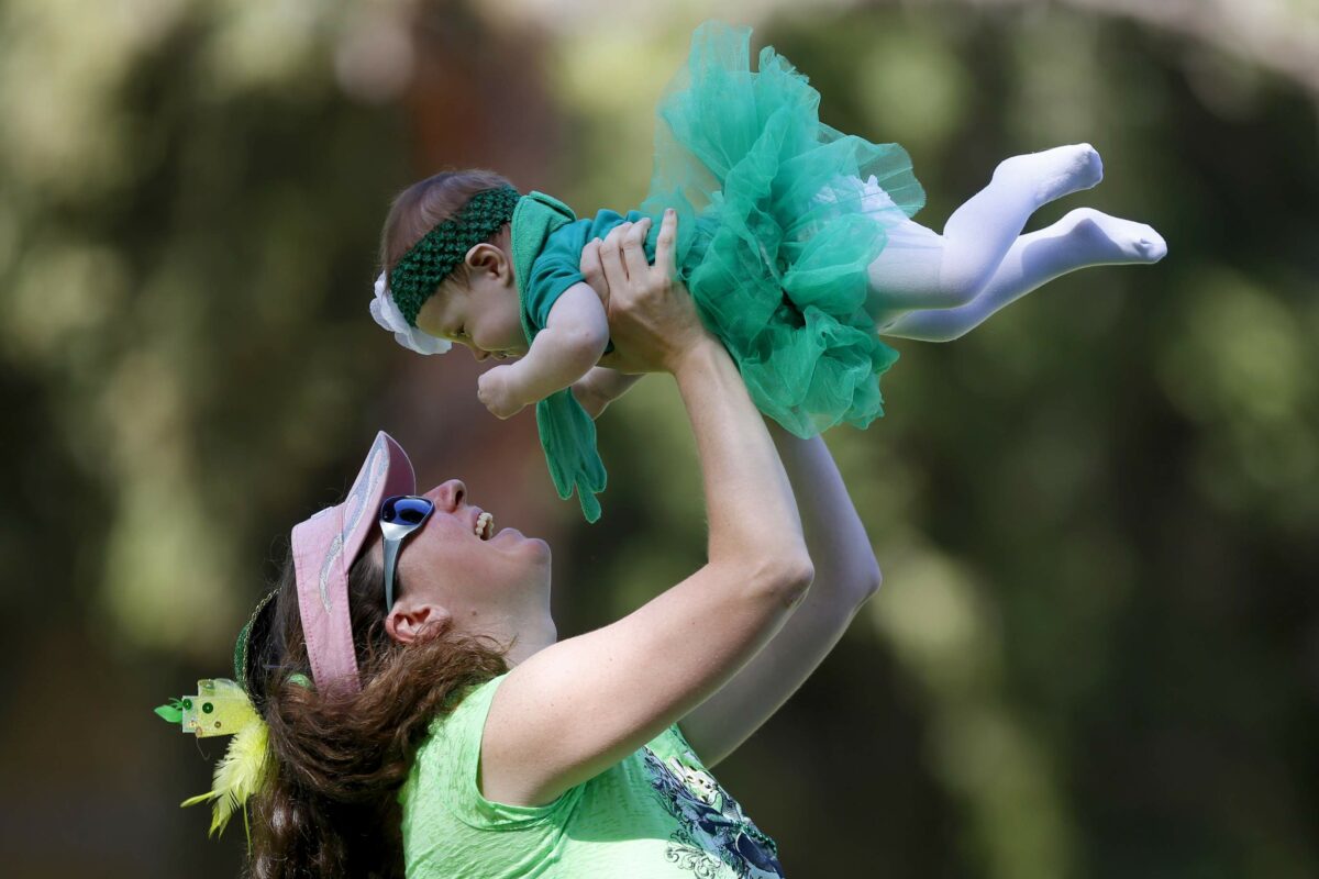 Cheriene Griffith holds up her daughter 7-month-old daughter Aurora at Juilliard Park before the St. Patrick's Day 5K in Santa Rosa, on Sunday, March 16, 2014. (Beth Schlanker/The Press Democrat)