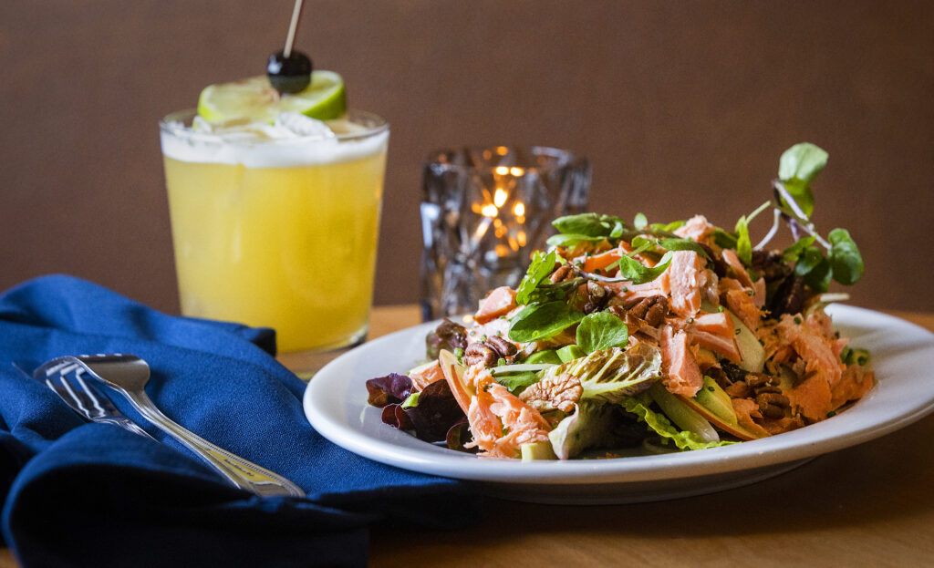Smoked Trout + Baby Lettuces wit apple, fennel, avocado, pecans and lemon vinaigrette with a Pisco Punch cocktailfrom Easy Rider in Petaluma on Tuesday, March 1, 2022. (John Burgess/The Press Democrat)