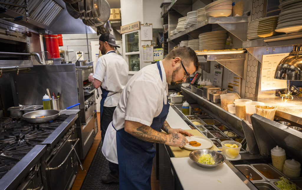 Chef Jared Rogers, left, and kitchen manager Lloyd Norton prepare southern favorites in the kitchen at Easy Rider in Petaluma on Tuesday, March 1, 2022. (The Press Democrat Staff)