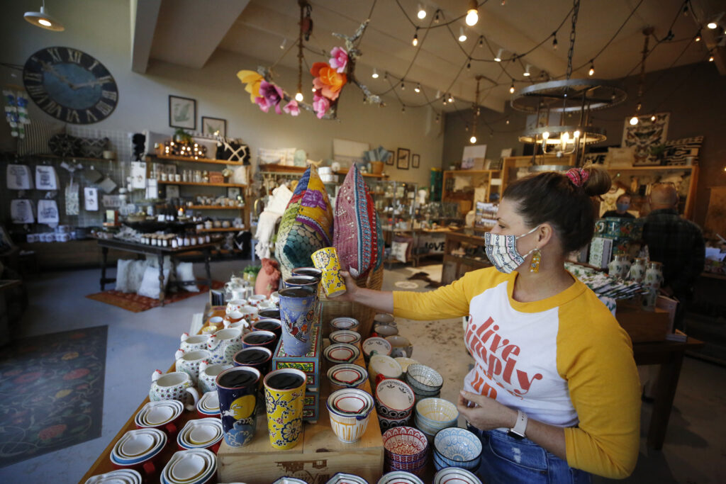 Faith Parker, owner of Boho Bungalow, straightens up items for sale at the boutique in Occidental, Calif., on Thursday, May 13, 2021. (Beth Schlanker/Sonoma Magazine)