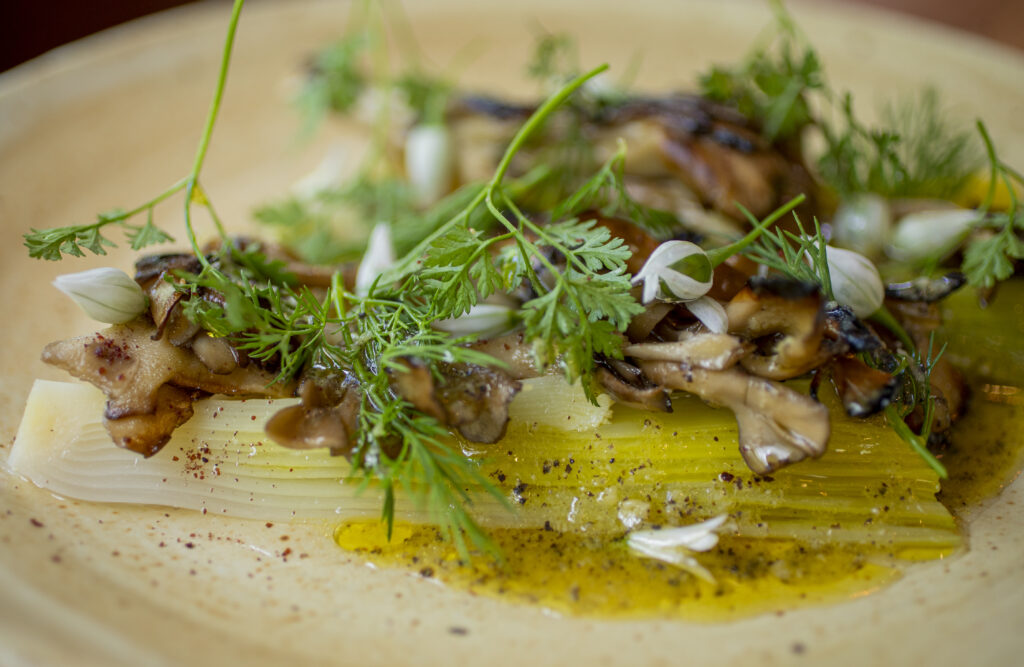 Chef Bryan Olivers leeks and mushrooms at Little Saint during Fridays grand opening in downtown Healdsburg on April 22, 2022. (Chad Surmick / The Press Democrat)