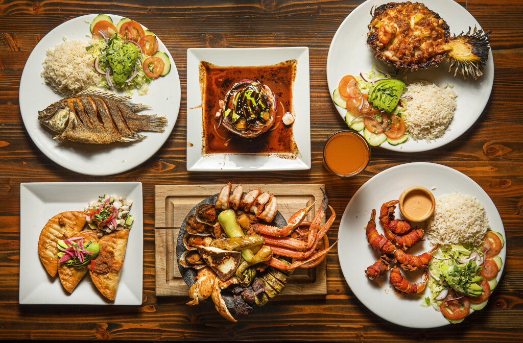 Clockwise from top left, Whole Deep Fried Tilapia, Torre de Mariscos,Pina Rellena, Camarones a la Momia, Molecajete Mar y Tierra and Tacos Dorados de Picadillo from Pezcow in Windsor on Friday, April 1, 2022. (John Burgess/The Press Democrat)