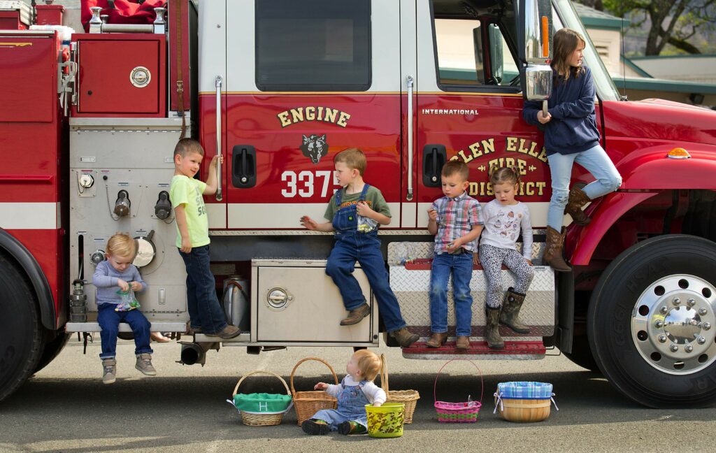 Kids lounge on the local fire truck while sampling the goodies from their baskets at the 30th annual Glen Ellen Easter egg hunt at Dunbar School. (John Burgess/The Press Democrat)
