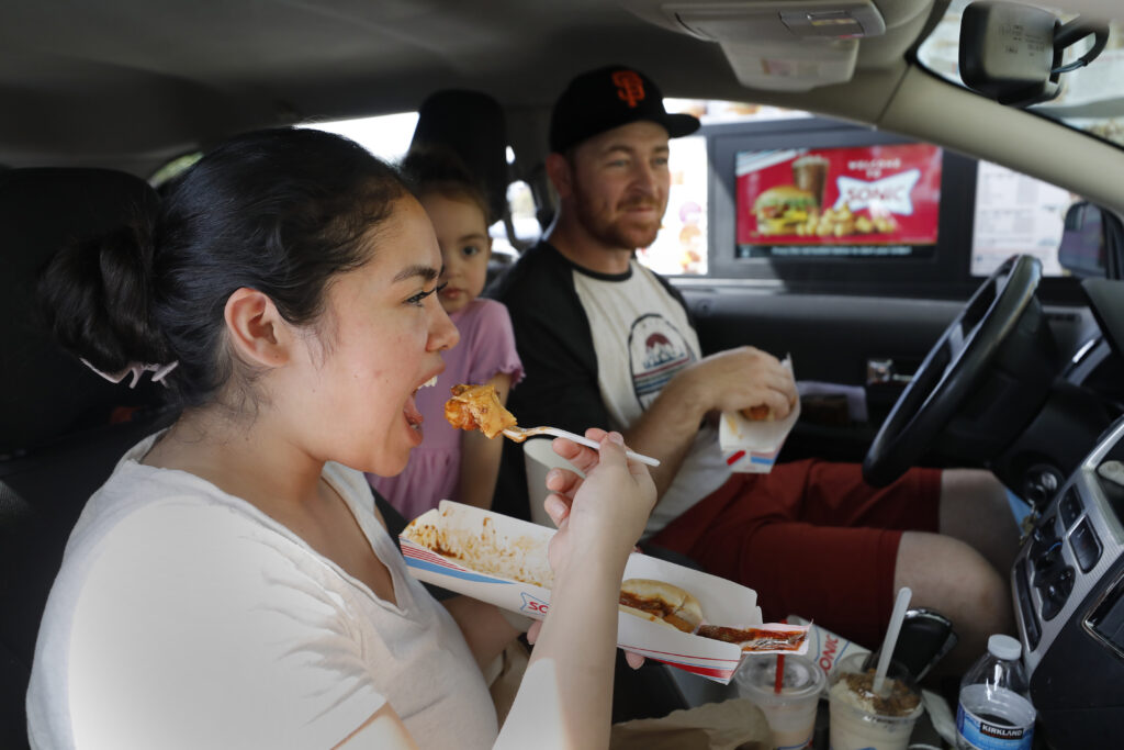 Sonic Drive-In fans Suri Newman, her husband Dale, their daughter Zoe, 3, center, and son Ezra, 5, not pictured, eat lunch at the newly opened Sonic Drive-In on Santa Rosa Ave. in Santa Rosa, Calif., on Thursday, April 7, 2022.(Beth Schlanker/The Press Democrat)