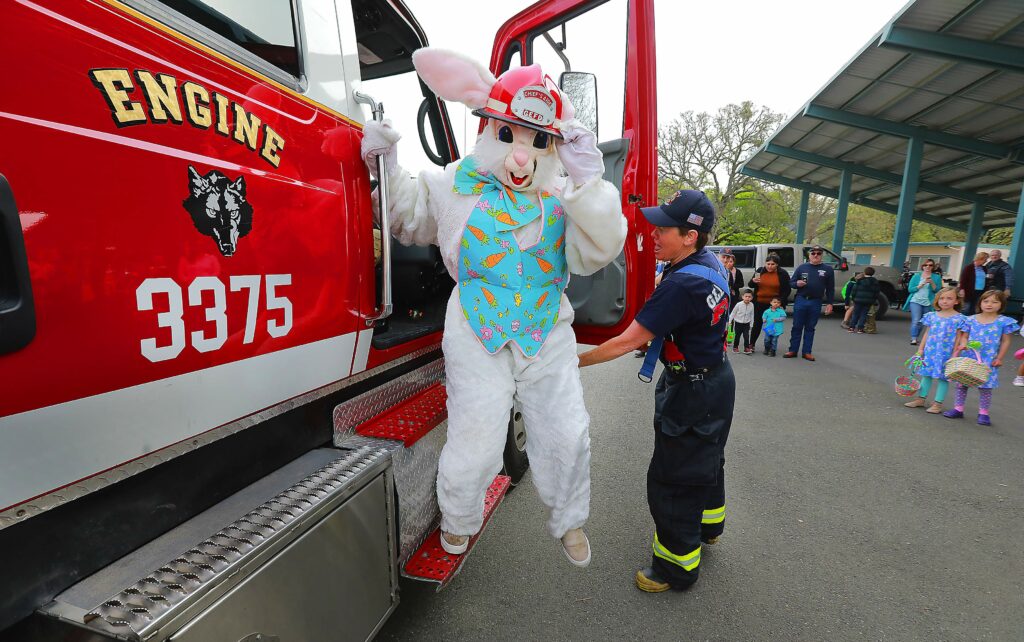 The Easter Bunny arrives aboard a Glen Ellen firetruck for the 30th annual Glen Ellen Easter egg hunt at Dunbar School. (John Burgess/The Press Democrat)