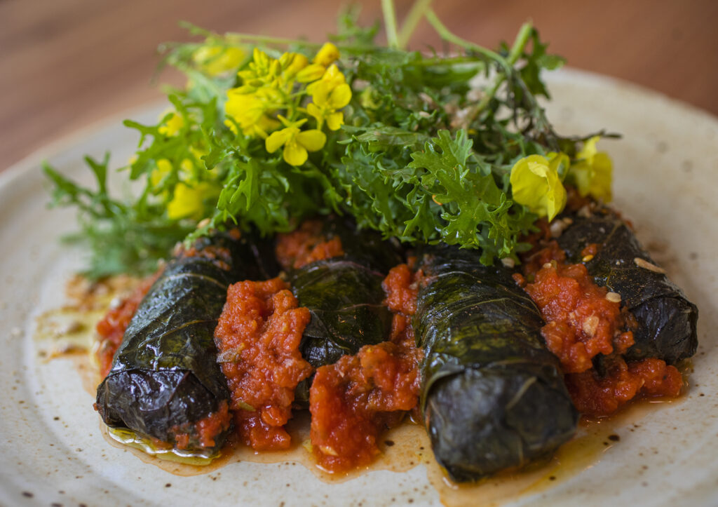 Chef Bryan Oliver's stuffed collard greens with beet merges, tomato sauce and sunflower seeds at Little Saint in downtown Healdsburg on April 22, 2022. (Chad Surmick / The Press Democrat)