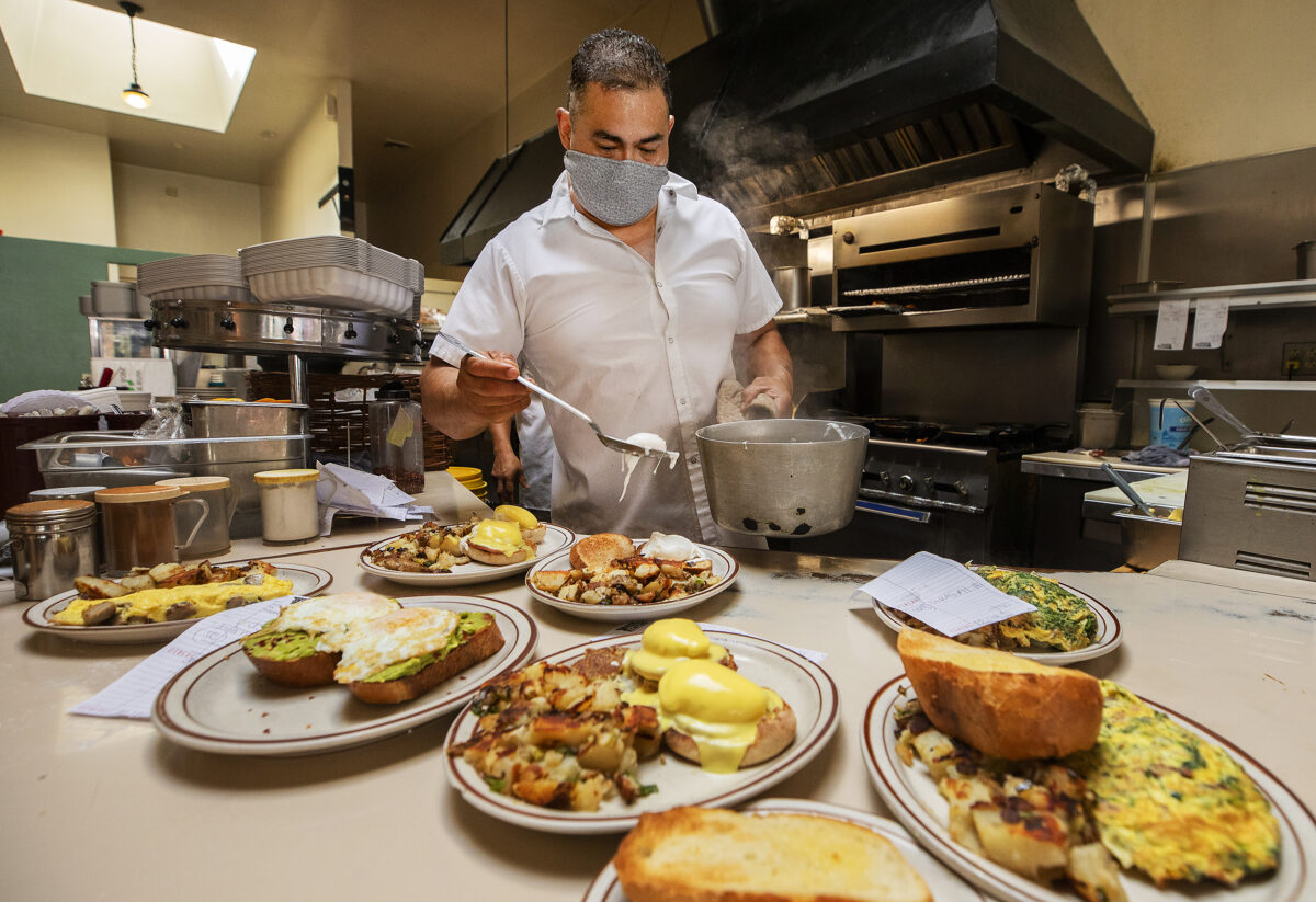 Cook Jose Perez serves up plates of breakfast at Omelette Express in Santa Rosa on Friday, May 21, 2021. Sonoma County restaurants and hotels are struggling to hire enough workers as the summer season and state's full reopening approaches. (Photo by John Burgess/The Press Democrat)