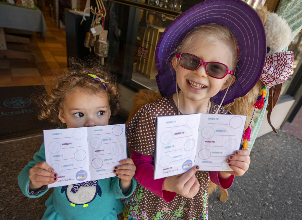 Talitha, 3, left, and her sister Isabel Blair, 4, show off the stickers they collected from downtown Santa Rosa businesses on Tuesday, March 16, 2021. Downtown Santa Rosa businesses are hoping to drum up some business with an Easter "Egg" Hunt where kids can collect stickers from businesses and turn them in for prizes. (John Burgess/The Press Democrat)