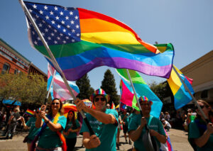 Kevin Witham, center, waves a pride flag as and other Sutter Health Santa Rosa employees participate in the Sonoma County Pride Parade in Santa Rosa, California, on Saturday, June 1, 2019. (Alvin Jornada / The Press Democrat)