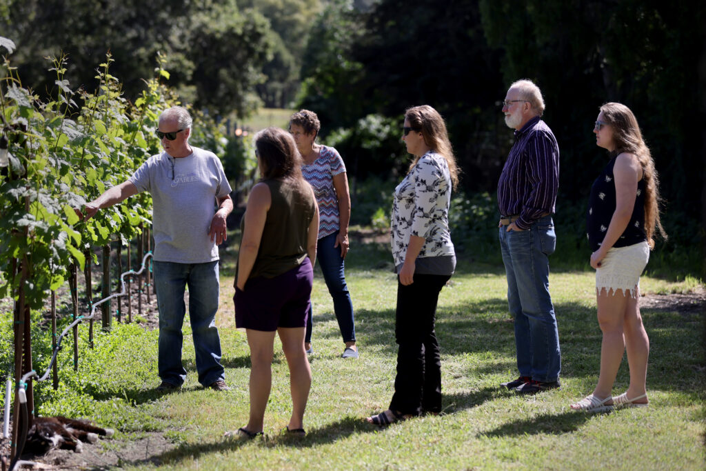 Owner Larry Willis, left, gives a vineyard tour for guests visiting from Anchorage, Alaska at The Gables Wine Country Inn in Santa Rosa, Calif., on Sunday, May 1, 2022. (Beth Schlanker/The Press Democrat)