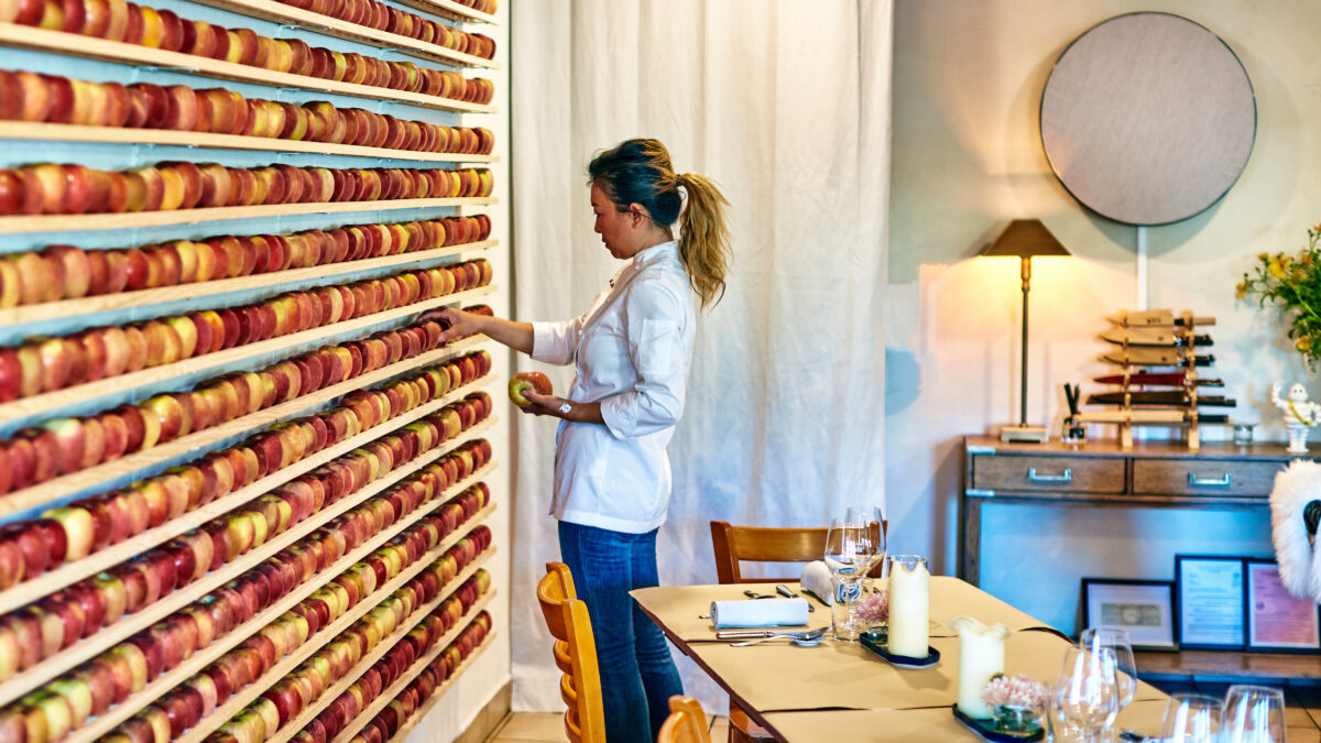 Heidy He arranges fresh apples on the wall before the start of service. (Kim Carroll/for Sonoma Magazine)