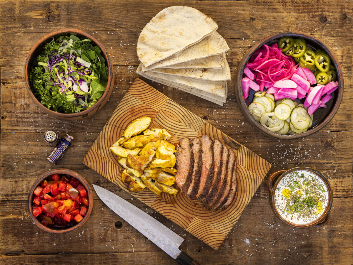A Pita Bar with (clockwise from top left) herbs and salad, pita bread, farmer's market pickles, mint yogurt sauce, chicken and beef shawarma and tomatoes from Cristina Topham, owner of Spread Kitchen in Sonoma. (John Burgess/The Press Democrat)