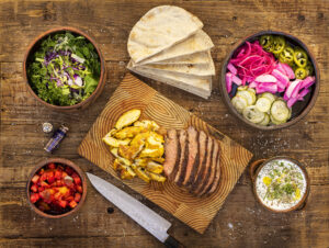 A Pita Bar with (clockwise from top left) herbs and salad, pita bread, farmer's market pickles, mint yogurt sauce, chicken and beef shawarma and tomatoes from Christina Topham, owner of Spread Kitchen in Sonoma. (John Burgess/The Press Democrat)
