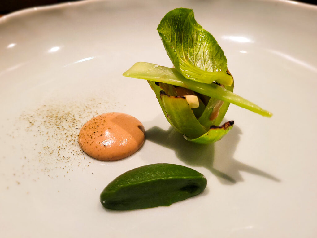 Grilled boy choy stem, charred bok choy puree, burnt cocnut peanut sauce and pickled young ginger at Locavore restaurant in Bali. (Heather Irwin/The Press Democrat)