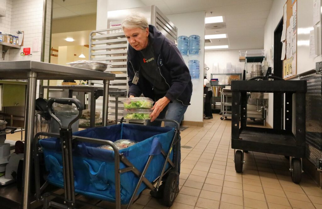 June Michaels, founder of Food Runners, collects uneaten food from The Grove Cafe in Santa Rosa on Wednesday, Nov. 13, 2019. (Christopher Chung/ The Press Democrat)