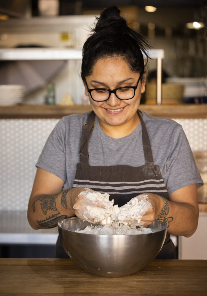 Indigo Reyna uses her fingers to press lard into the biscuits at the Naked Pig in Santa Rosa, The lard is rendered from cooking pork shoulders and then filtering the fat.. (John Burgess/Sonoma Magazine)