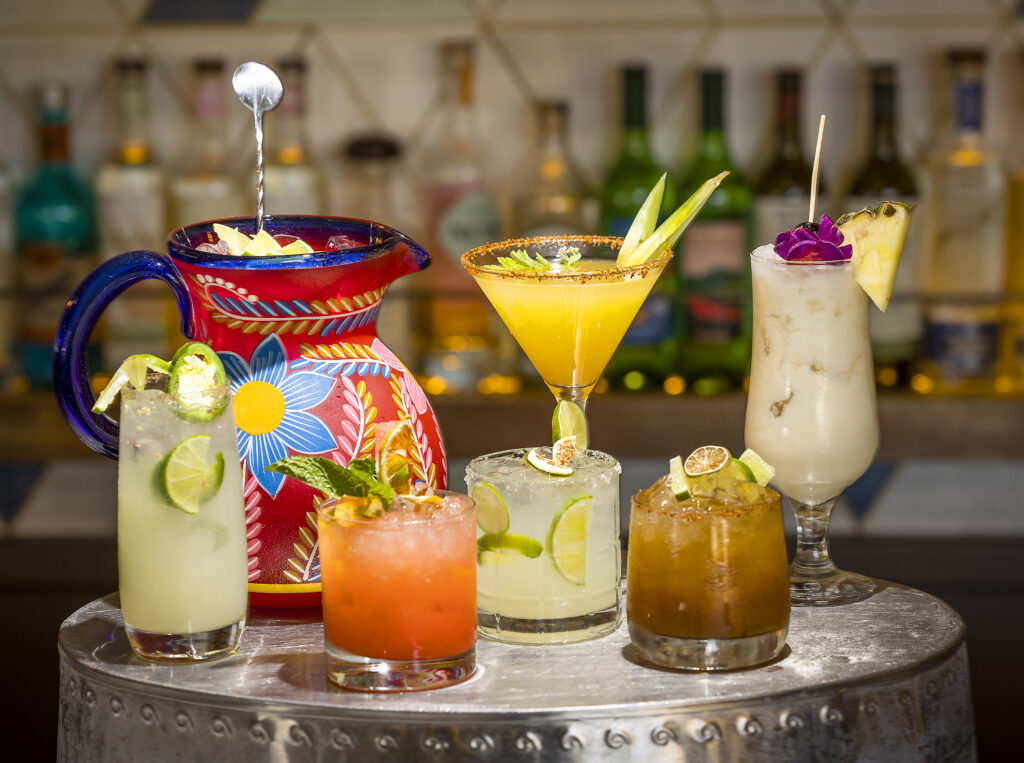 From left, the tequila based cocktails from Kina's Kitchen & Bar in Sonoma, La Kina, pitcher of Classic Margarita, Watermelon Smash, Classic Margarita, Pineapple Margarita, Tamarind Margarita and a Piña Colada. (John Burgess/The Press Democrat)