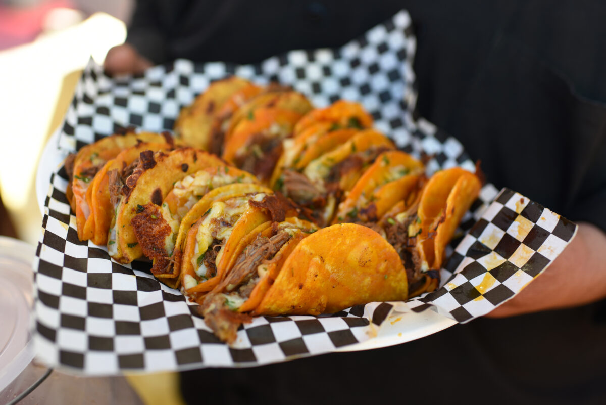 Jose Cazares, right, owner of the Gio y Los Magos Mexican Grill truck holding a plate of birria tacos during the ribbon cutting celebration of the new Mitote Food Park on Sebastopol Road in the Roseland neighborhood of Santa Rosa, Calif. on Thursday, July 14, 2022. (Erik Castro / For The Press Democrat)