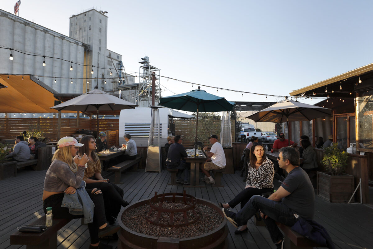 Aine Fitzgerald, from left, Rachael Brackett, Heloisa Maruch and Leonardo Melo have drinks at The Block food park in Petaluma, on Saturday, May 14, 2022. (Beth Schlanker/The Press Democrat)