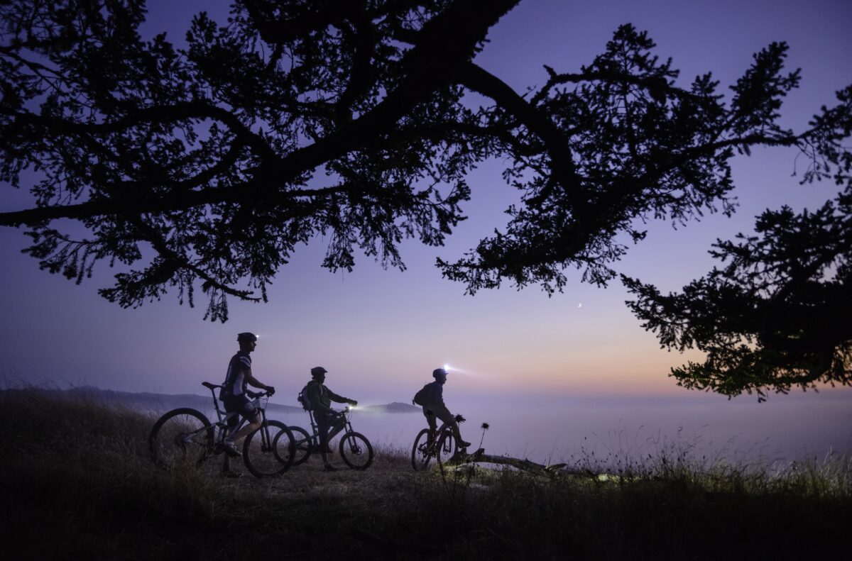 Three mountain bikers take in the view of fog covered coastal valleys along Northern California's Sonoma Coast. (Jerry Dodrill Photography)