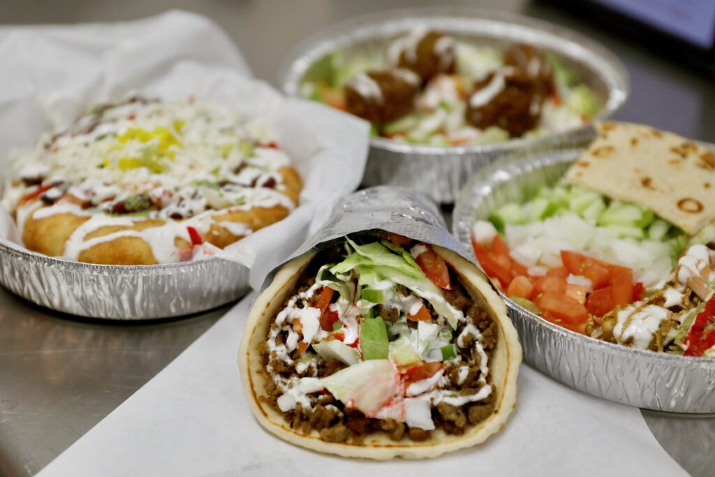 (Clockwise from bottom) A lamb gyro, fry bread with beans, falafel salad, and chicken and rice plate at ZamZam in Santa Rosa, Calif. on Monday, July 25, 2022. (Beth Schlanker/The Press Democrat)