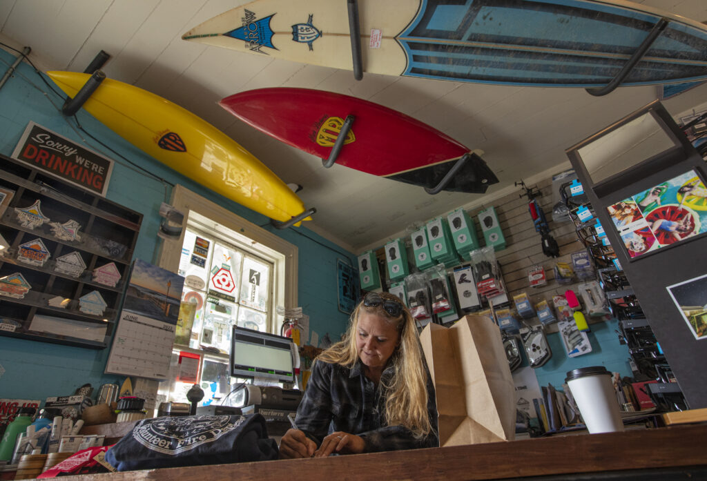 Northern Lights Surf Shop Sarah Dougherty fills an order of sweatshirts in her store, designs comes from local artist and friends. (Chad Surmick / The Press Democrat)
