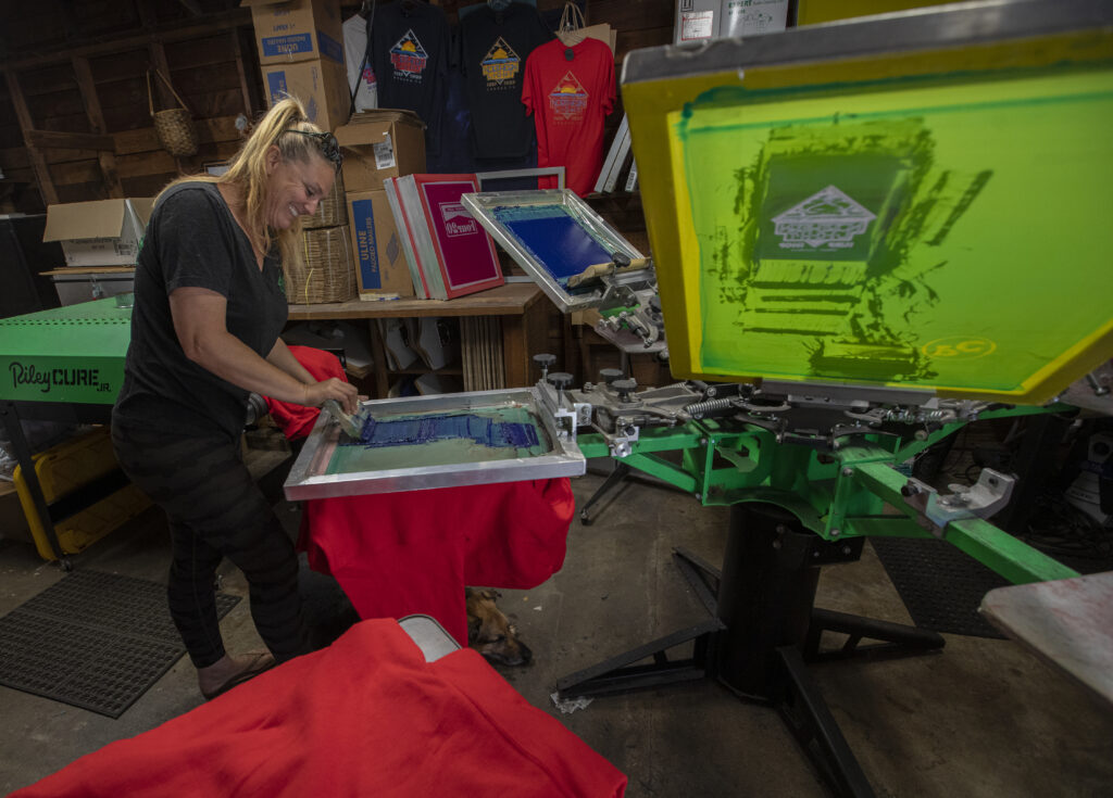 Northern Lights Surf Shop Sarah Dougherty prints sweatshirts in her workshop for her store; designs comes from local artist and friends. (Chad Surmick / The Press Democrat)