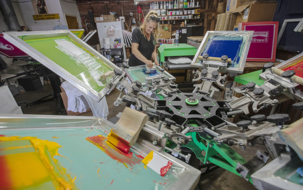 Northern Lights Surf Shop Sarah Dougherty prints sweatshirts in her workshop for her store, designs comes from local artist and friends.(Chad Surmick / The Press Democrat)