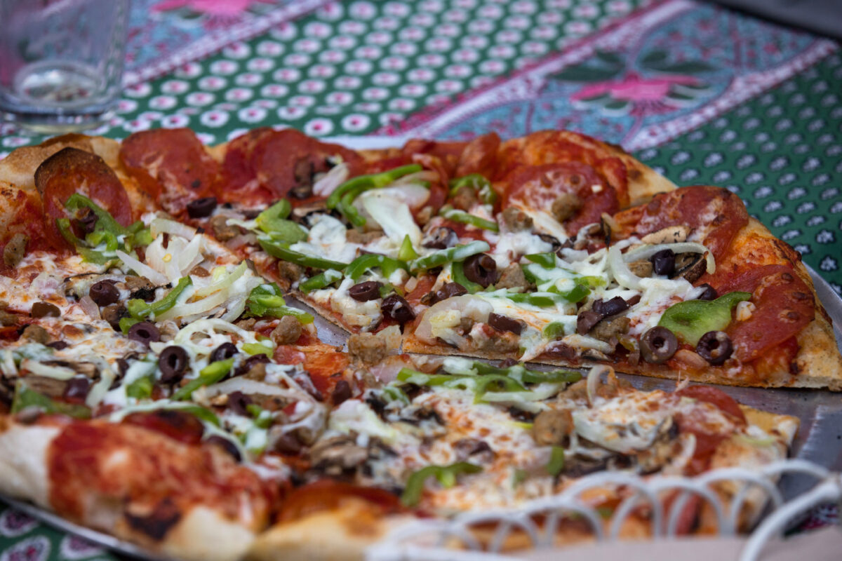 A pizza is ready for eating, on one of the outdoor tables, during community pizza night with live music at Raymond's Bakery, in Cazadero, Calif., on Friday, May 13, 2022. (Photo by Darryl Bush / For The Press Democrat)