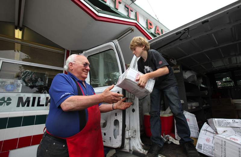 Ben Spohr, 11, helps his grandfather Art “The Pasta King“ Ibleto unload boxes of spaghetti in preparation for opening day of the Sonoma County Fair in 2010. (Crista Jeremiason)