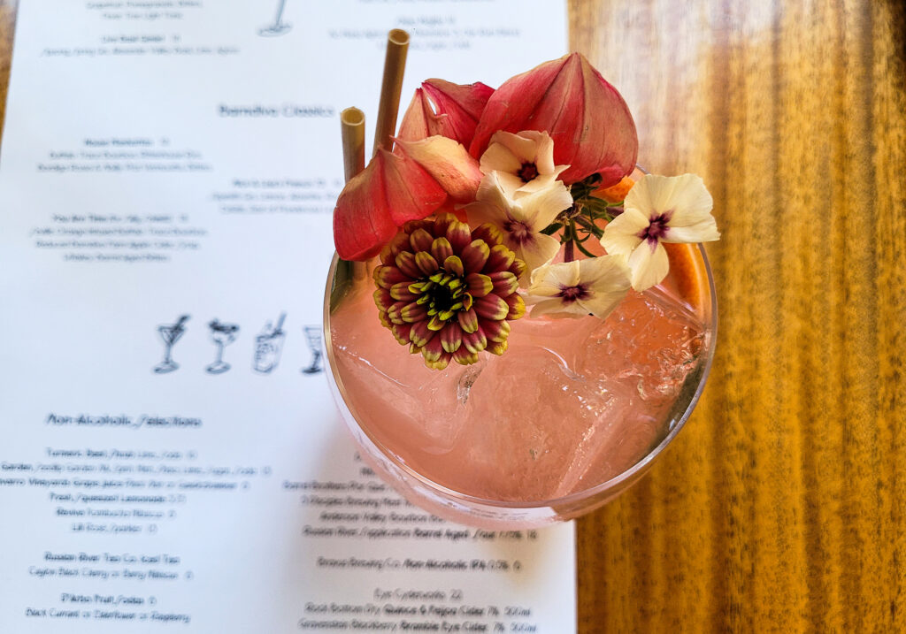 Summer cocktail is garnished with flowers at Barndiva in Healdsburg. (Heather Irwin / Press Democrat)